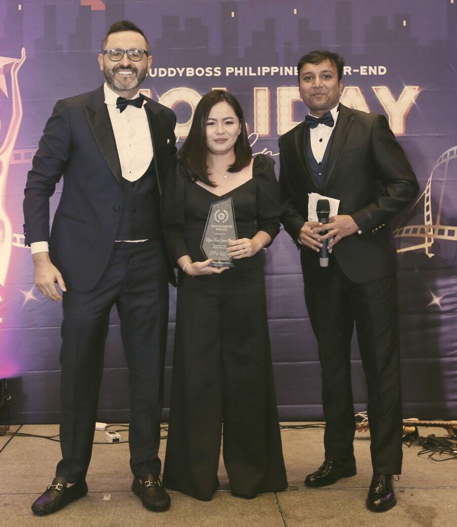 Tom and a colleague presenting an award to Alyssa on stage.