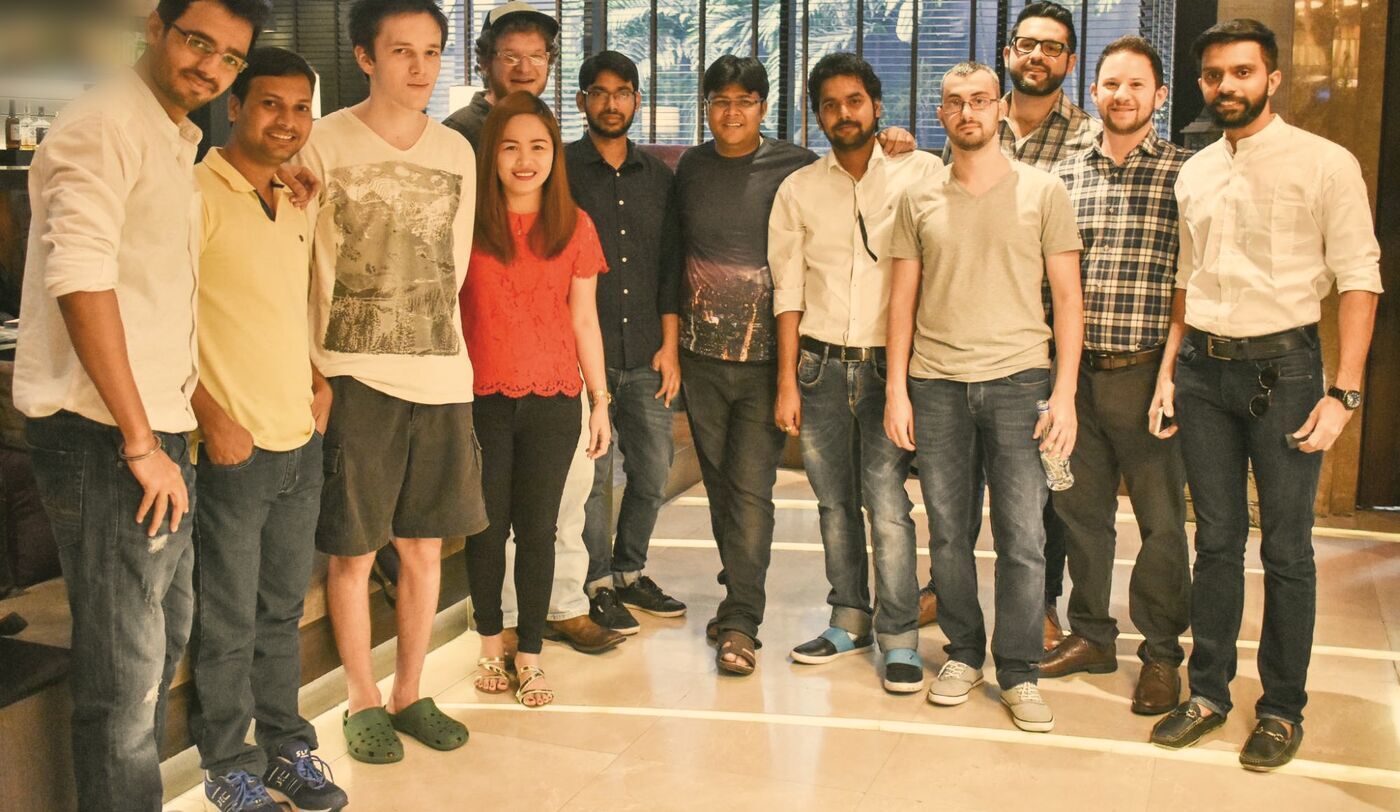 Tom with thirteen BuddyBoss teammates standing together in a hotel lobby in Bangkok.